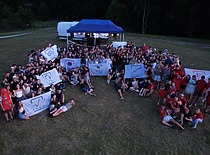 Didelis studentų būrys, grupėmis iškėlę savo fakultetinių atstovybių vėliavas.