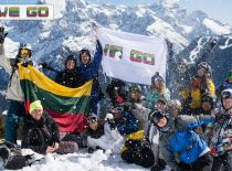 Studentai kalnuose laikantys WE GO vėliavą ir Lietuvos vėliavą.