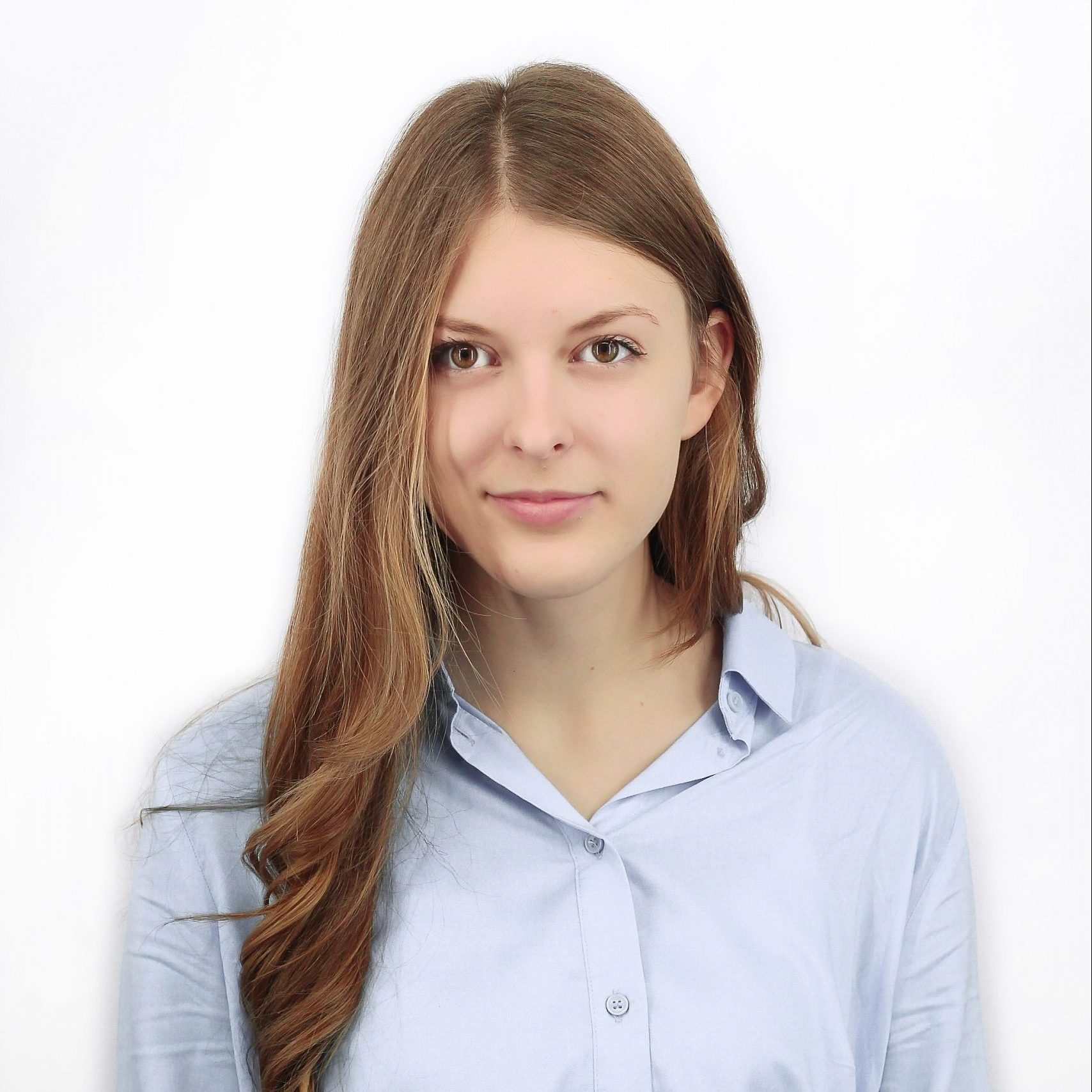 Ilgų, rudų plaukų mergin, šviesiai mėlynais marškinėliais.