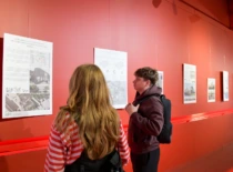 Mergina ir vaikinas prekybos centre apžiūrinėja KTU architektūros magistrų baigiamųjų darbų parodą