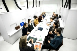 Maisto instituto mokymai maisto banko savanoriams, dalyviai susėdę prie balto stalo