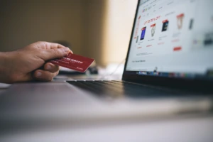 Žmogus apsiperka kompiuteriu su bankine kortele